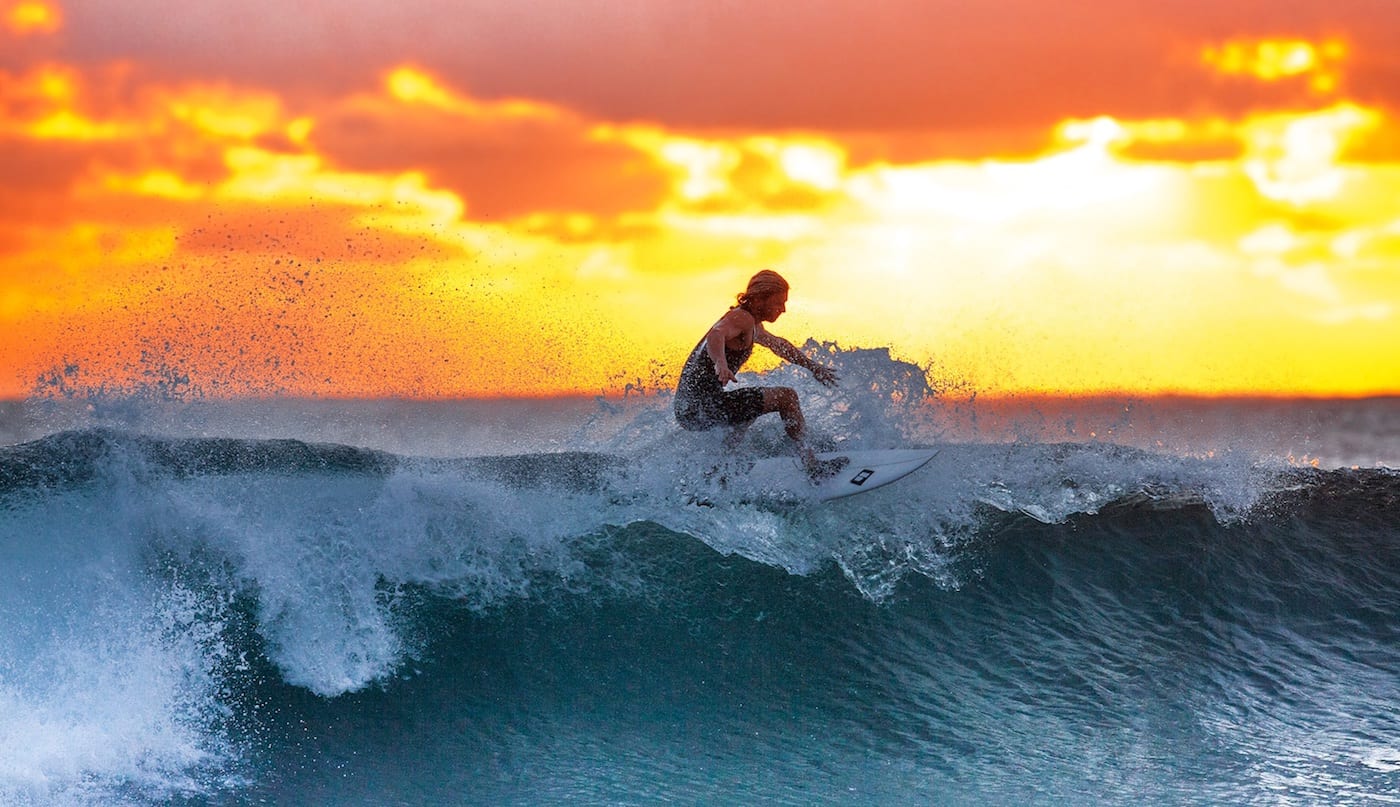 Local Showing us how to surf a wave during sunset.jpeg
