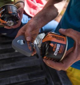 Man opening his original label jetboil fuel 4 season blend for his breakfast at his campsite