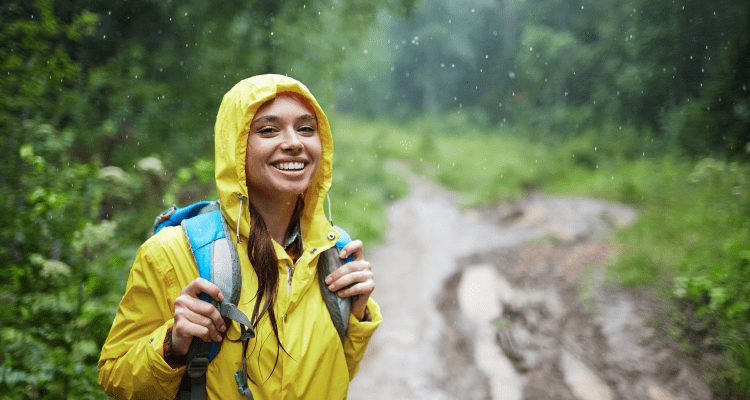 Woman with soaked gear hiking during the rain