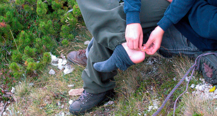 Man treating a blister during a hiking trip