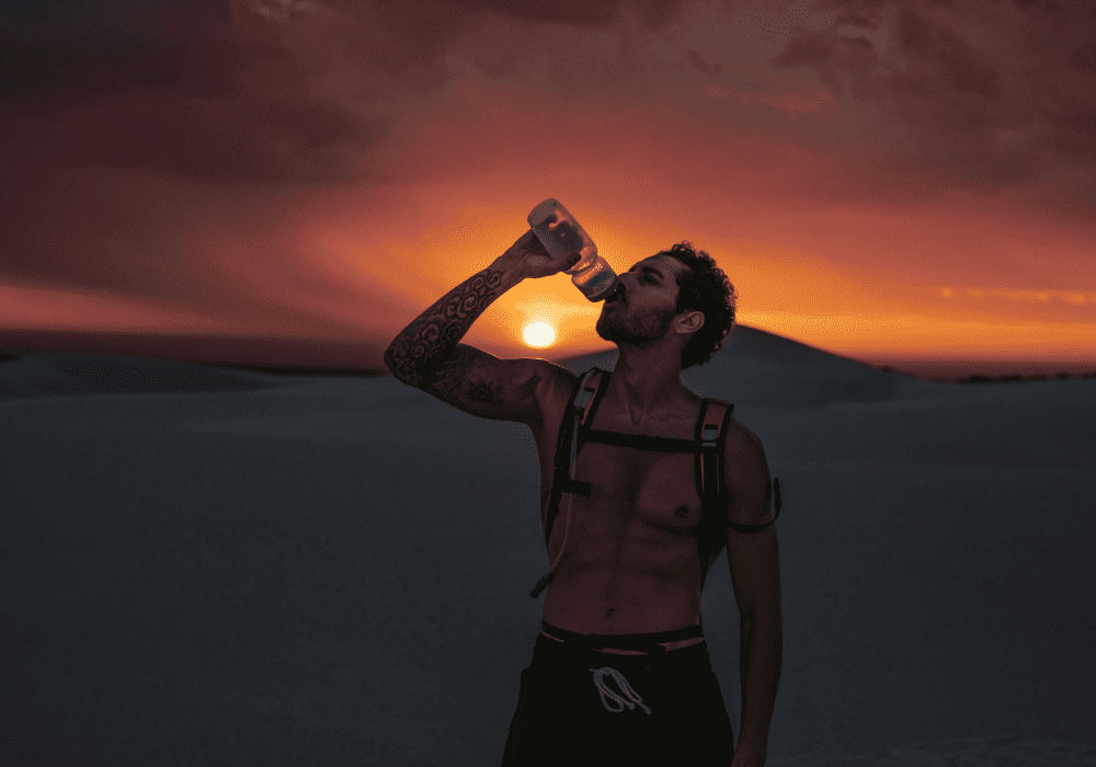 hiker drinking water during an evening hike in the desert