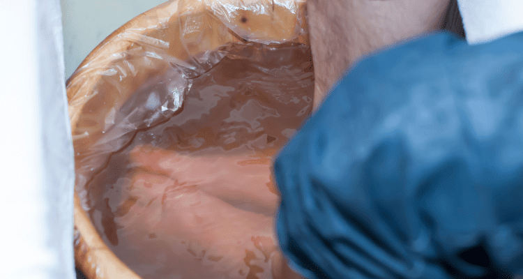 Man soaking his feet in magnesium foot bath after a long hike