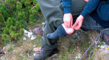 hiker treating his blisters while on the trail