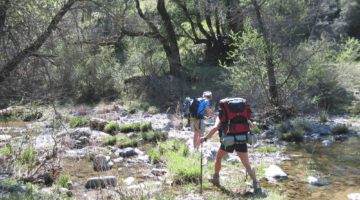 Backpackers crossing a river