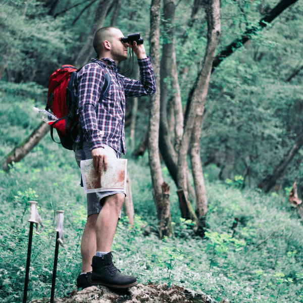 Man finding adventures with his binoculars on the hiking trail