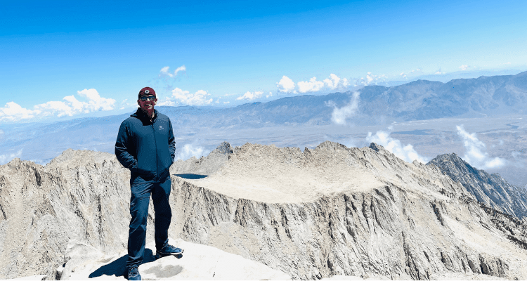 Michael Putnam aka Putty standing atop Mount Whitney, Californias, tallest mountain peak.
