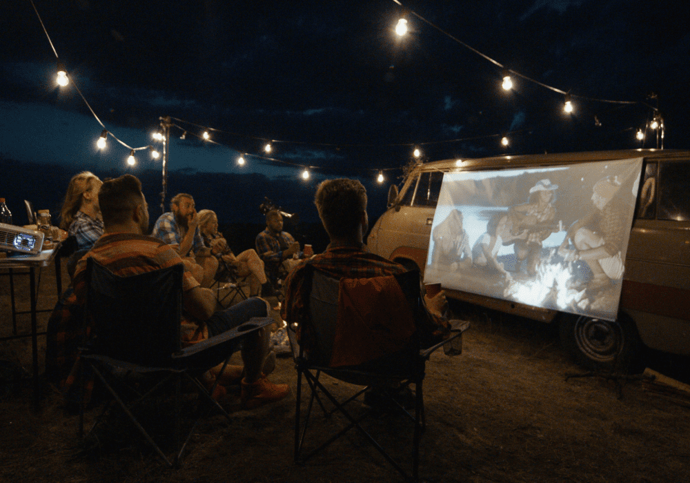 Friends Watching a Movie via Projector while camping
